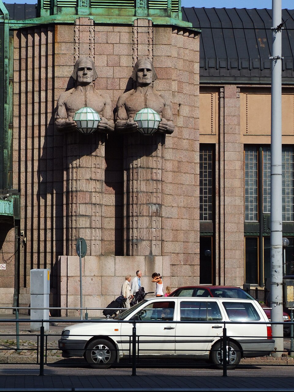 Helsingin päärautatieaseman kiviset lyhdynkantajat aurinkoisena päivänä
